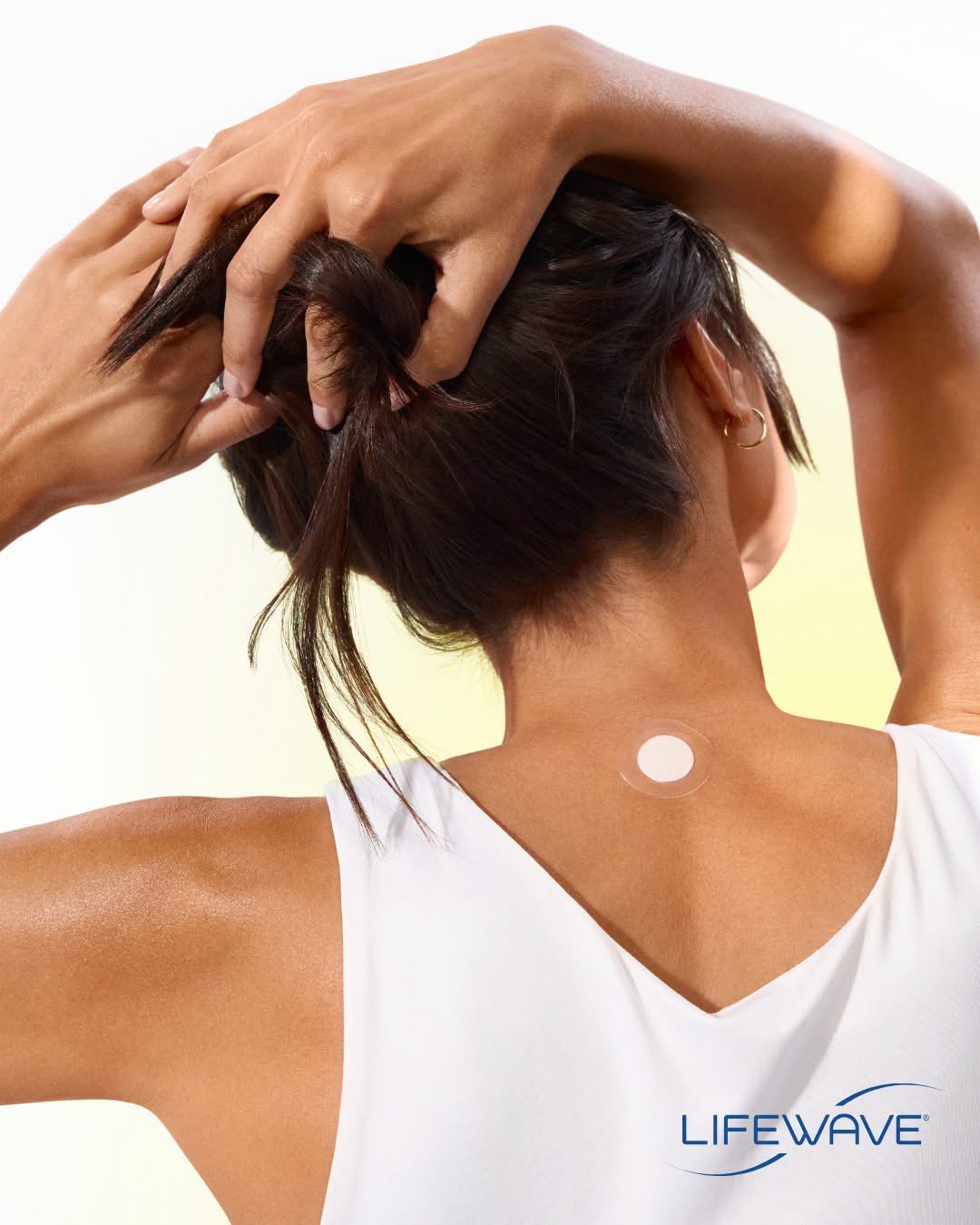 Woman wearing a LifeWave patch on the upper back